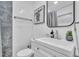 Modern bathroom featuring a sleek vanity, toilet, decorative mirror and gray tiled accent wall at 946 Charlotte Ave, Sarasota, FL 34237