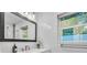 Bright bathroom featuring a large mirror, contemporary fixtures, and a white countertop at 946 Charlotte Ave, Sarasota, FL 34237