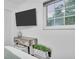 Bright bedroom featuring light wood floors, a television, and a leafy green plant at 946 Charlotte Ave, Sarasota, FL 34237