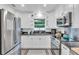 Well-lit kitchen with stainless steel appliances, white cabinets, granite countertops, and window at 946 Charlotte Ave, Sarasota, FL 34237