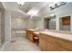 A bright primary bathroom offers dual sinks, soaking tub, glass block shower, and tile flooring at 1000 San Lino Cir # 1034, Venice, FL 34292