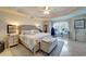 Bright main bedroom with a tray ceiling, a plush bed, and an adjacent work space at 1000 San Lino Cir # 1034, Venice, FL 34292