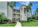 Elegant condo building with lush landscaping, balconies, and a charming walkway at 1000 San Lino Cir # 1034, Venice, FL 34292