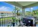 Screened patio with lovely view of the lake, palm trees, seating, and a television at 1000 San Lino Cir # 1034, Venice, FL 34292