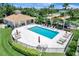 An outdoor community pool area surrounded by lush landscaping and comfortable lounging furniture at 1000 San Lino Cir # 1034, Venice, FL 34292
