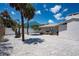 Backyard featuring shell ground cover, an outdoor seating area, and tropical landscaping at 1201 Big Oak Ln, Sarasota, FL 34242