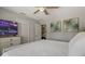 Light and airy bedroom with a television, closet, and colorful palm tree wall art at 1201 Big Oak Ln, Sarasota, FL 34242
