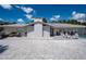 Charming single-story home with a white brick chimney, comfortable patio furniture, and a shell-covered yard at 1201 Big Oak Ln, Sarasota, FL 34242