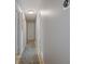 Hallway with neutral walls, a long rug, and doorways leading to various rooms in the home at 1201 Big Oak Ln, Sarasota, FL 34242