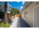 The walkway leads to a fenced yard with tropical landscaping providing shade and privacy at 1201 Big Oak Ln, Sarasota, FL 34242