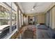 Bright sunroom with waterfront views, ceiling fan, sliders, and comfortable furniture for relaxing at 1201 Big Oak Ln, Sarasota, FL 34242