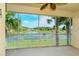 Relaxing screened balcony with a scenic view of the water and lush palm trees at 1251 Burgos Dr # 303, Sarasota, FL 34238