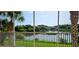 Balcony view showcasing a serene pond surrounded by lush greenery and mature trees at 1251 Burgos Dr # 303, Sarasota, FL 34238