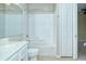 Well-lit bathroom includes a bathtub with a shower, and a white vanity with a sink at 1251 Burgos Dr # 303, Sarasota, FL 34238