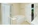 Bathroom featuring a soaking tub, a glass-enclosed shower, and neutral color scheme at 1251 Burgos Dr # 303, Sarasota, FL 34238