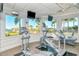 Cardio room with treadmills and elliptical machines overlooking beautiful lake and community at 1251 Burgos Dr # 303, Sarasota, FL 34238