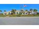 Beautiful community clubhouse with a manicured lawn, mature palms, and the American flag waving proudly at 1251 Burgos Dr # 303, Sarasota, FL 34238