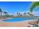 Inviting community pool with lounge chairs and palm trees, perfect for relaxation and recreation at 1251 Burgos Dr # 303, Sarasota, FL 34238