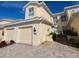 Charming yellow two-story home featuring a brick driveway and a two-car garage at 1251 Burgos Dr # 303, Sarasota, FL 34238