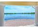 Expansive lake view from a covered patio with brick pavers and white railings in a peaceful community at 1251 Burgos Dr # 303, Sarasota, FL 34238