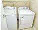 Bright laundry room with washer, dryer, and overhead shelving at 1251 Burgos Dr # 303, Sarasota, FL 34238