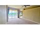Bright living room featuring neutral carpeting, a ceiling fan, and a large glass door with a water view at 1251 Burgos Dr # 303, Sarasota, FL 34238