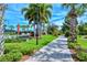 Picturesque community walkway with lush landscaping, palm trees, and colorful foliage on a sunny day at 1251 Burgos Dr # 303, Sarasota, FL 34238