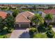 An aerial view captures this home's lush landscaping, three-car garage, and beautiful terracotta roof at 13026 Ramblewood Trl, Bradenton, FL 34211