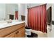 Bright bathroom with a single vanity and shower-tub combo with striped curtain at 13026 Ramblewood Trl, Bradenton, FL 34211