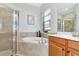 Bright bathroom featuring a soaking tub, glass enclosed shower and single vanity at 13026 Ramblewood Trl, Bradenton, FL 34211