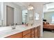 This bathroom features double sinks and a view into the main bedroom at 13026 Ramblewood Trl, Bradenton, FL 34211