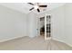 Bedroom features French doors, ceiling fan, neutral walls, and carpet at 13026 Ramblewood Trl, Bradenton, FL 34211