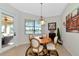 This charming dining area features a wood table, seating for four, and natural light from a window with lake views at 13026 Ramblewood Trl, Bradenton, FL 34211