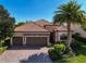 Beautiful single-Gathering home features a well-manicured lawn, large driveway, and a terracotta roof at 13026 Ramblewood Trl, Bradenton, FL 34211