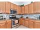 Modern kitchen featuring stainless steel appliances, granite countertops, and tile backsplash at 13026 Ramblewood Trl, Bradenton, FL 34211