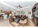 The open concept living room has a ceiling fan, a decorative rug, and access to the kitchen and other living areas at 13026 Ramblewood Trl, Bradenton, FL 34211