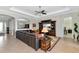 Comfortable living room featuring a large leather sofa, tray ceiling, and open access to the kitchen at 13026 Ramblewood Trl, Bradenton, FL 34211
