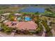 Aerial view of the resort-style pool area with palm trees, lounge chairs, and a luxurious clubhouse at 13714 Messina Loop # 202, Bradenton, FL 34211