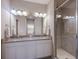 Bathroom with double sink vanity, granite countertop, modern fixtures, and glass shower at 13714 Messina Loop # 202, Bradenton, FL 34211