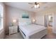 Bright bedroom features a ceiling fan, ensuite bathroom and soothing ocean-themed wall decor at 13714 Messina Loop # 202, Bradenton, FL 34211