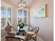 Bright breakfast nook features a glass table, wicker chairs, and plantation shutters at 13714 Messina Loop # 202, Bradenton, FL 34211