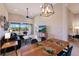 Open living area with dining table, lanai access, and modern furnishings, including a ceiling fan and TV at 13714 Messina Loop # 202, Bradenton, FL 34211