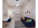 Bright living room featuring neutral walls, ceiling fan, blue sofa, desk, and decorative wall art and mirrors at 13714 Messina Loop # 202, Bradenton, FL 34211