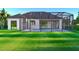 Backyard view featuring a screened-in pool and spacious lawn, perfect for outdoor living at 1573 Greenley Rd, North Port, FL 34286