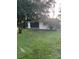 Expansive backyard with mature trees and a covered patio for outdoor enjoyment at 1725 Briar Creek Ln, Sarasota, FL 34235