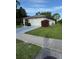 A single story home with a well-manicured lawn and attached garage with beautiful landscaping at 1725 Briar Creek Ln, Sarasota, FL 34235