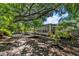 Landscaped backyard with mature tropical landscaping, patio, and screened in porch at 1857 Siesta Dr, Sarasota, FL 34239