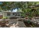 Backyard features stone paver patio, lush tropical landscaping, and a screened-in porch at 1857 Siesta Dr, Sarasota, FL 34239