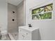 Bright bathroom with walk-in tile shower and modern vanity at 1857 Siesta Dr, Sarasota, FL 34239