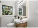 Charming bathroom featuring modern vanity, illuminated mirror, and ample natural light at 1857 Siesta Dr, Sarasota, FL 34239